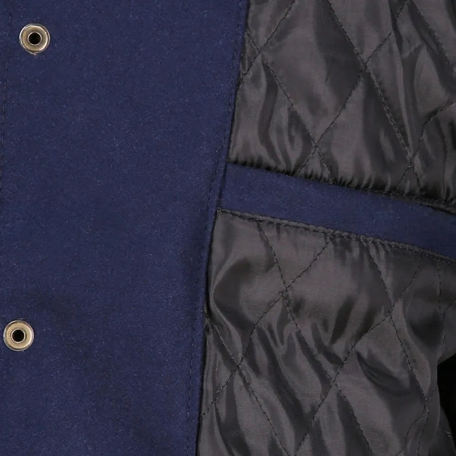 Close-up of a blue and black quilted jacket with button details.
