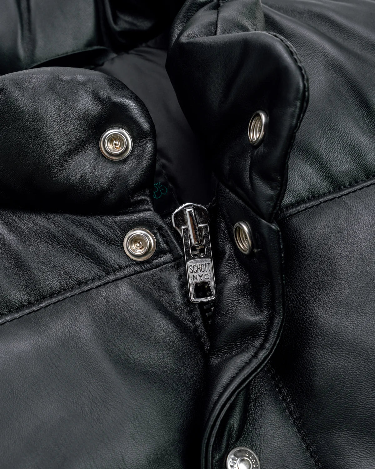 Collar zoom showcase of the Leveljacket Matte Black leather quilted puffer vest, detailing its wide horizontal thermal baffles, high insulated stand-up collar, front vertical zipper pockets, snap-button closure placket, and elasticated lower back hem.