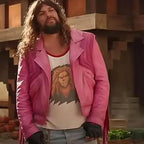 Person wearing a pink jacket over a graphic t-shirt with a lion design, standing outdoors.