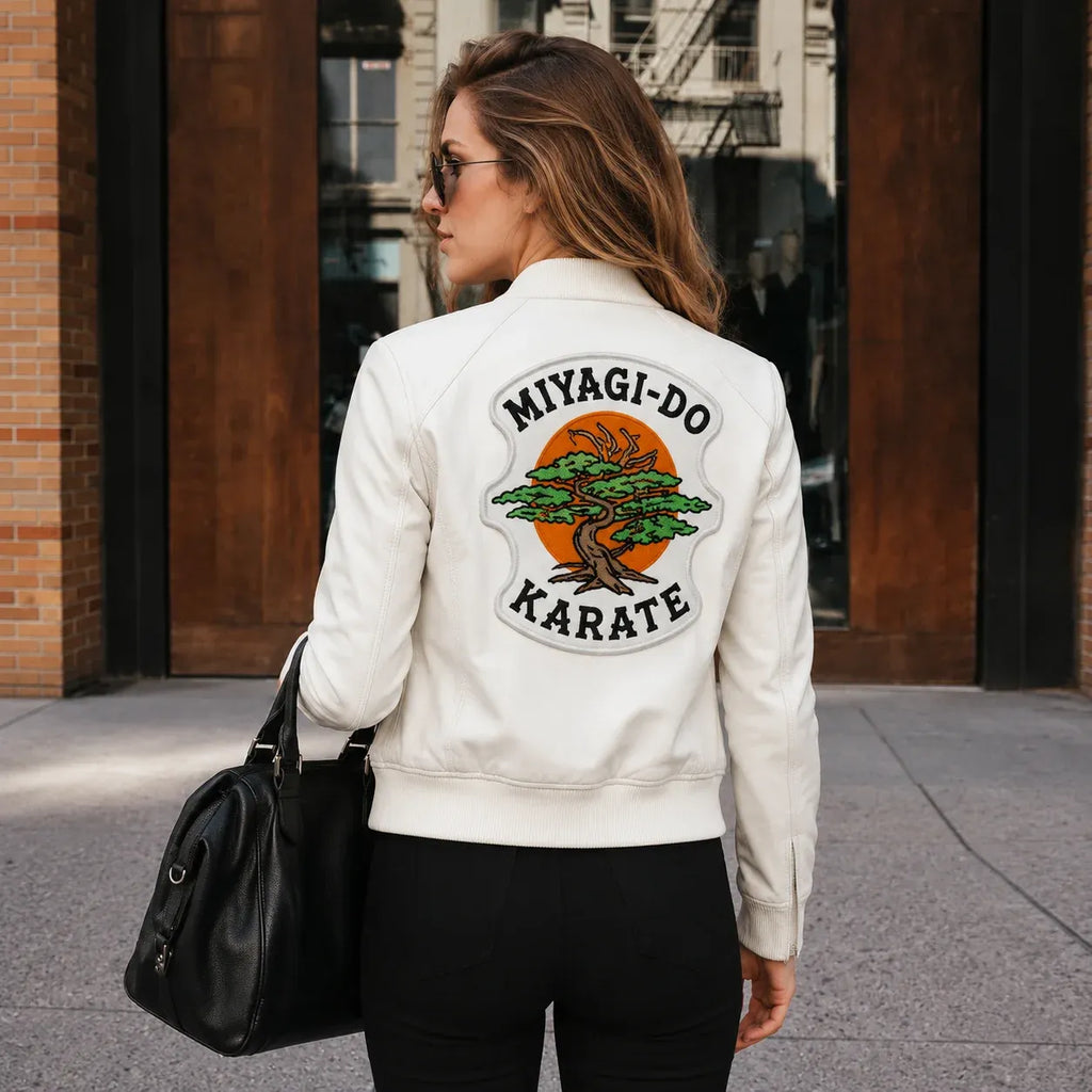 Woman wearing a white jacket with 'MIYAGI-DO KARATE' design, walking on a street.